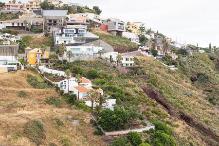 View of the coast of Madeira and the village of Pontu de Garageu on a cloudy summer day.の写真素材