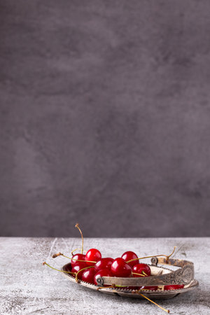 Ripe cherry berries in a vintage metal plate.の写真素材