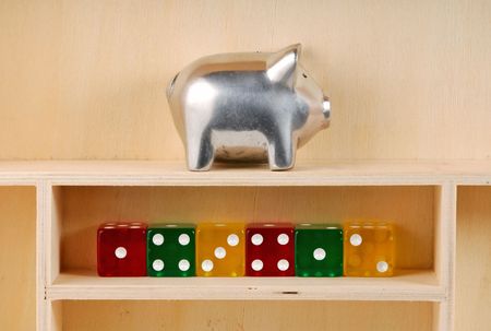 Wooden Shelf With Dice and a Piggy Bankの写真素材