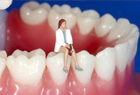 Miniature Woman Sitting on Teethの写真素材