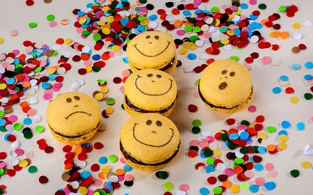 Different macaron cookie faces with confetti around themの写真素材