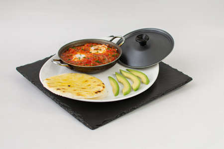 Shakshuka in a frying pan on a white backgroundの写真素材
