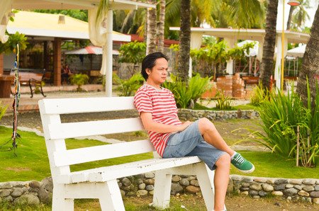 Man in deep thought in a park bench photoの写真素材