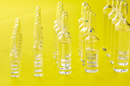Ampoules with medicine on yellow background.の写真素材