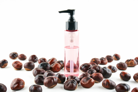 Cosmetic jar and chestnuts on white background.の写真素材