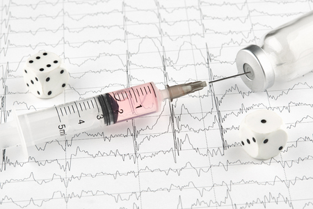 Syringe, phial with medicine and dice on MRI cardiogram.の写真素材