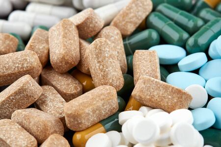 Close-up photo of many brown, green and blue pills.