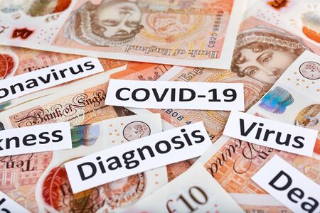 Coronavirus, COVID-19 headline clippings on United Kingdome 10 pounds banknotes.