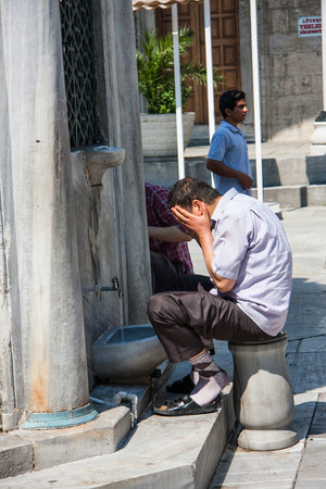 Istanbul, Turkey, - April 15, 2016: man washes himself before prayer in the courtyard of the mosque Eminonu in Istanbul. Image with GPS tags.のeditorial素材