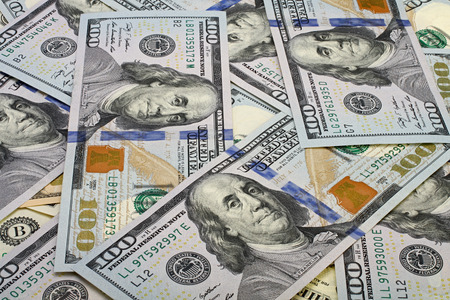 A pile of one hundred dollar bills as background.