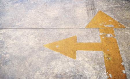 Traffic arrow signage on an asphalt road indicating a detour left turn.の写真素材