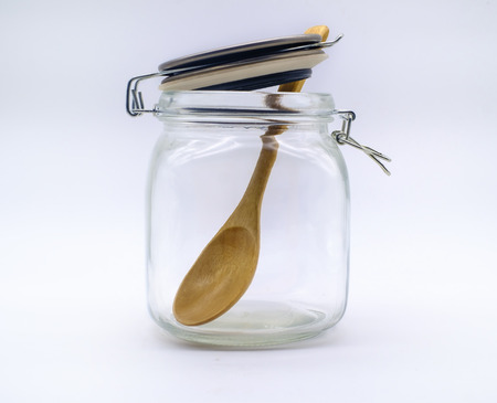 Empty jars and wooden spoon on white backgroundの写真素材
