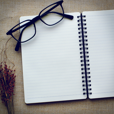 Journal book and eyeglasses on canvas backgroundの写真素材