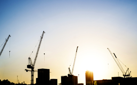 Industrial landscape with silhouettes of cranes on the sunset backgroundの写真素材