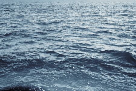 Water surface with ripples and sunlight reflectionsの写真素材