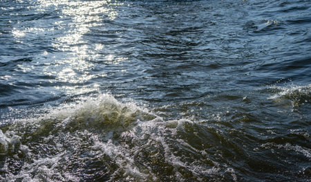 Water surface with ripples and sunlight reflectionsの写真素材