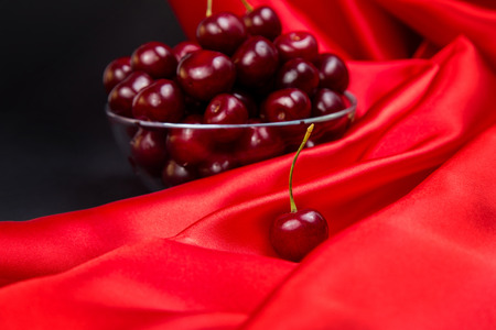 Red large cherry on red and black bright backgroundの写真素材