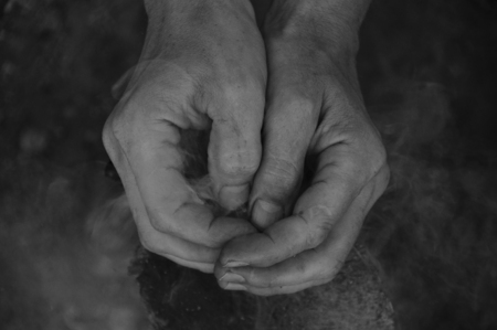 Hands clasped together. Adult man, smoke, log background.の写真素材