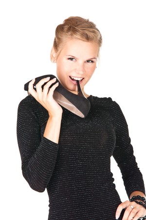 Picture of a girl in black dress with a shoe in her handの写真素材