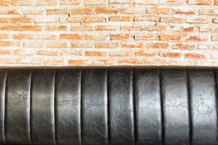 close up Leather sofa at orange brick wall