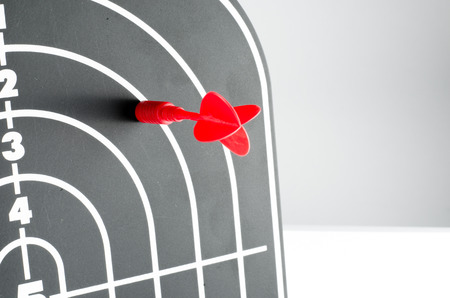red arrow shooting at heart position of profile shape black dart board 