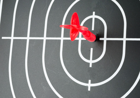 red arrow shooting at center of black dart boardの写真素材