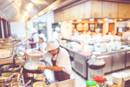 Blurred background : Groups of Chef cooking in the open kitchen,customer can see they cooking at food counter, cooking chef with light bokehの写真素材