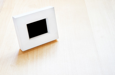 White photo frame on wooden table ,Template mock up for adding your photo in to black area and leave space for adding text.の写真素材