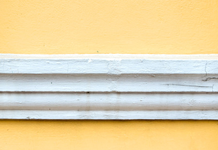 yellow erode painted concrete wall,grunge rough texture backgroundの写真素材
