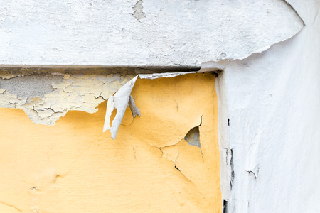 yellow erode painted concrete wall,grunge rough texture backgroundの写真素材