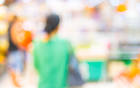 Blur background of woman customer select fresh product on shelf in supermarket.の写真素材