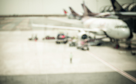 Blurred background : looking through terminal window to see airplane at airport.