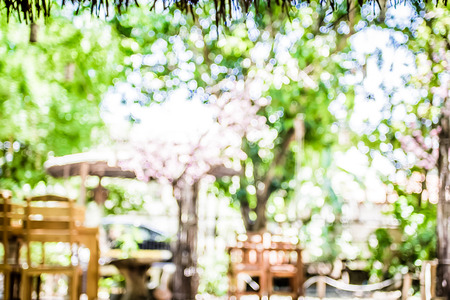 Blur background : Outdoor cafe in garden with wood table with boekh light.の写真素材