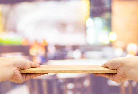 Two hand holding food plate made from wood isolated on white backgroundの写真素材