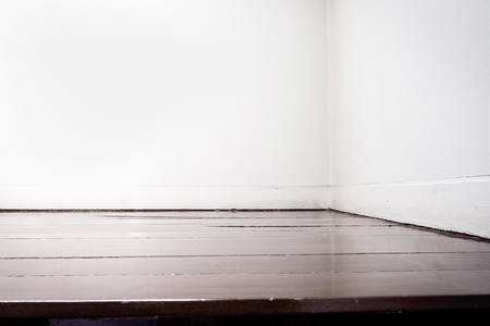 Empty white wall and dark brown parquet floor in perspective view.
