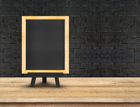 Menu blackboard on  Wooden Table top at black brick wall,Template mock up for display of your product,Business presentation.の写真素材