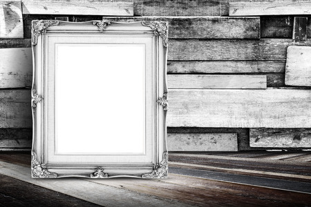 Blank white vintage photo frame leaning at plank wood wall and diagonal wood floor,Mock up for adding your designの写真素材