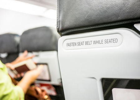Close up fasten seat belt at backrest on airplane.の写真素材