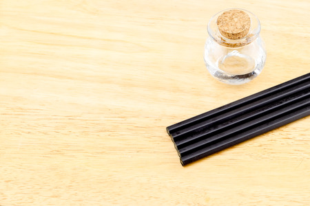 Glass bottle with cork and black pencil on wood table, Copy space for adding your content.の写真素材