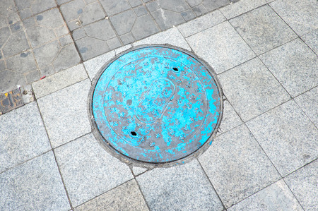 Blue manhold cover on street.の写真素材