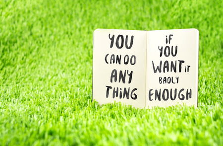Inspiration quote : " You can do anything if you want it badly enough" on notebook on grass ,Motivational typographic.の写真素材