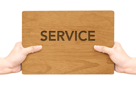 Hand holding dark brown wood signboard with service word isolated on white background,Business concept.の写真素材