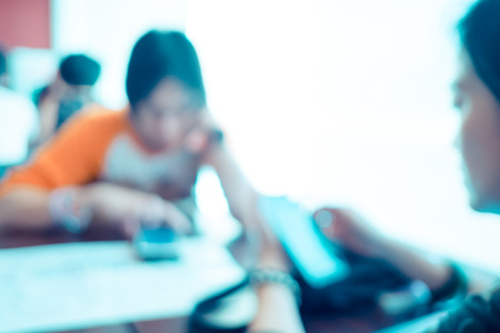 Blurred background : Customer look at mobile phone at restaurant blur background with bokeh.の写真素材