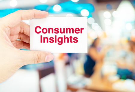 Hand holding Business card with Consumer insights word with blur customer at store background,Business concept.の写真素材
