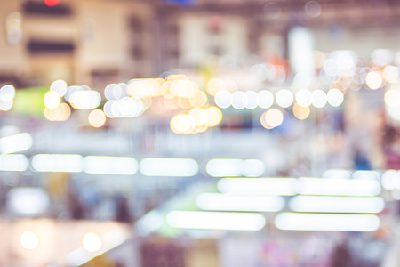 Blurred background: crowd of people in expo fair with bokeh light ,Vintage filter.の写真素材