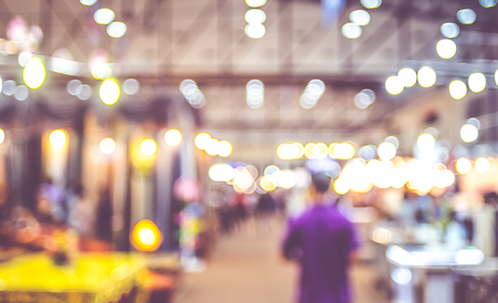 Blurred background : crowd of people in expo fair with bokeh light .の写真素材