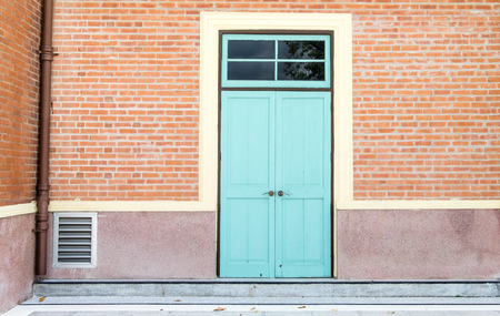 Blue door at orange brick wall,exterior building.の写真素材
