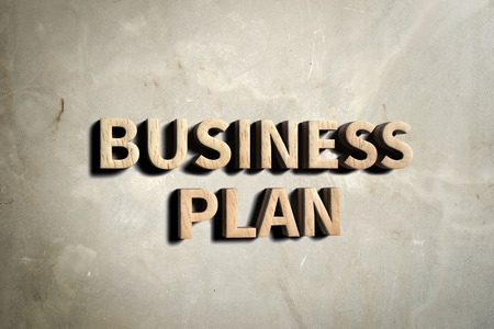 Business plan in wood texture on concrete wall,Business concept.の写真素材