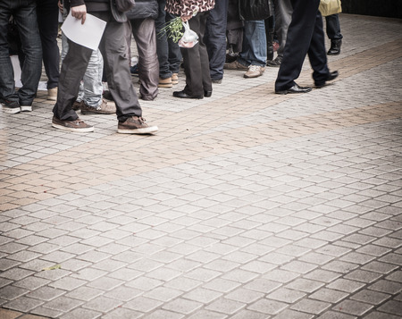 Group of people walk at pavement.