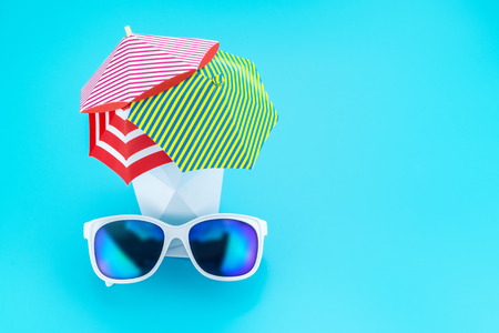 White sunglasses with polygon vase and beach umbrella,Vacation concept,leave space for adding text.の写真素材